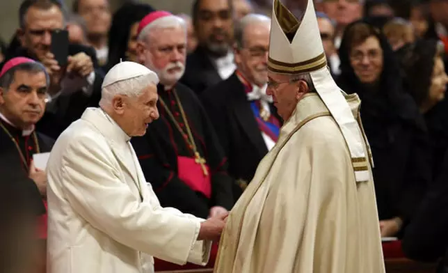 FILE - Pope Emeritus Benedict XVI, left, greets Pope Francis in St. Peter's Basilica at the Vatican, Saturday, Feb. 14, 2015. (AP Photo/Andrew Medichini, file)