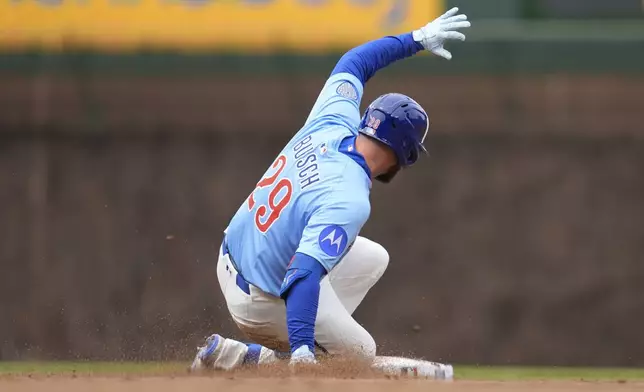 Chicago Cubs' Michael Busch (29) slides into second base for a double during the fourth inning of a baseball game against the San Diego Padres, Saturday, April 5, 2025, in Chicago. (AP Photo/Erin Hooley)
