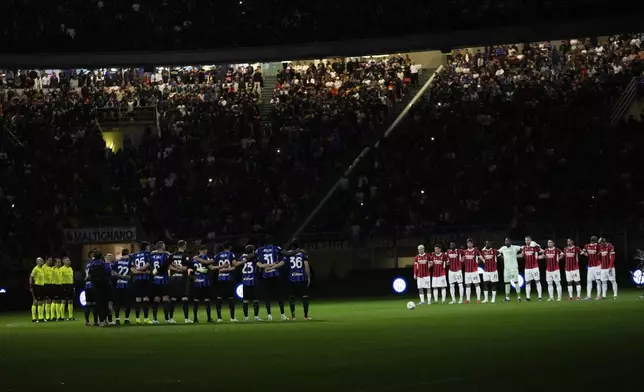Players stand during the minute of silence for Pope Francis before the Italian Cup semifinal second leg soccer match between Inter Milan and AC Milan at the San Siro stadium in Milan, Italy, Wednesday, April 23, 2025. (AP Photo/Luca Bruno)