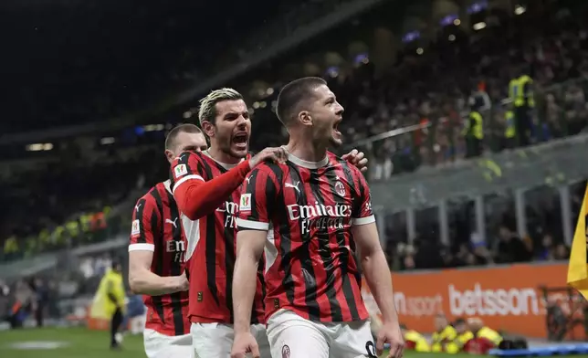AC Milan's Luka Jovic, front, celebrates after scoring during the Italian Cup semifinal second leg soccer match between Inter Milan and AC Milan at the San Siro stadium in Milan, Italy, Wednesday, April 23, 2025. (AP Photo/Luca Bruno)