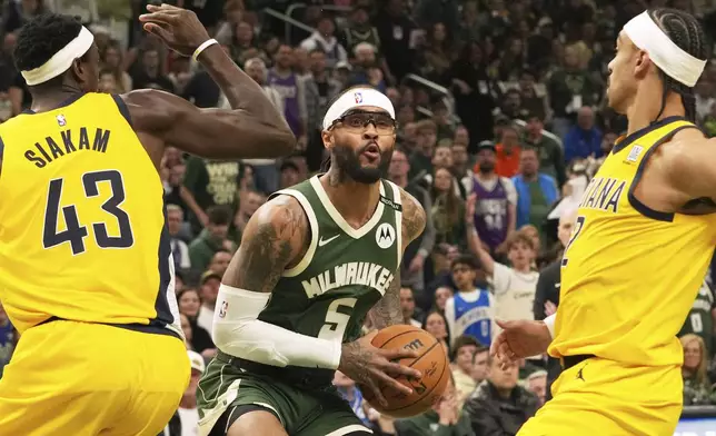 Milwaukee Bucks guard Gary Trent Jr., center, looks to pass the ball against Indiana Pacers forward Pascal Siakam, left, and guard Andrew Nembhard, right, during the first half in Game 3 of an NBA basketball first-round playoff series Friday, April 25, 2025, in Milwaukee. (AP Photo/Nam Y. Huh)