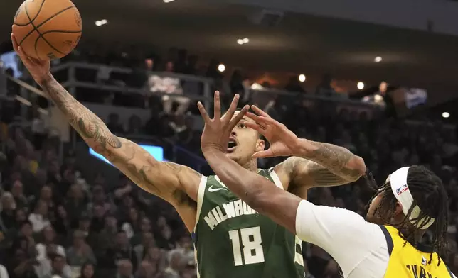Milwaukee Bucks forward Kyle Kuzma, left, drives to the basket against Indiana Pacers center Myles Turner, right, during the first half in Game 3 of an NBA basketball first-round playoff series Friday, April 25, 2025, in Milwaukee. (AP Photo/Nam Y. Huh)