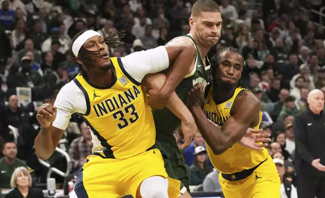 Milwaukee Bucks center Brook Lopez, center, battles for a rebound against Indiana Pacers center Myles Turner, left, and forward Aaron Nesmith during the first half in Game 3 of an NBA basketball first-round playoff series Friday, April 25, 2025, in Milwaukee. (AP Photo/Nam Y. Huh)
