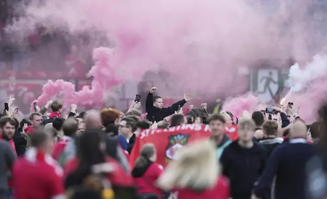 Wrexham players celebrate with fans as they win the English League One soccer match between Wrexham and Charlton Athletic at the Racecourse ground in Wrexham, Wales, Saturday, April 26, 2025. (AP Photo/Jon Super)