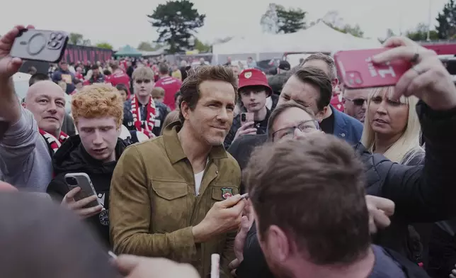 Wrexham co-owner Ryan Reynolds, center, arrives at the Racecourse ground stadium prior to the English League One soccer match between Wrexham and Charlton Athletic in Wrexham, Wales, Saturday, April 26, 2025. (AP Photo/Jon Super)