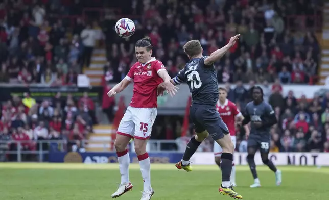 Wrexham's George Dobson, left, duels for the ball with Charlton Athletic's Greg Docherty during the English League One soccer match between Wrexham and Charlton Athletic at the Racecourse ground in Wrexham, Wales, Saturday, April 26, 2025. (AP Photo/Jon Super)