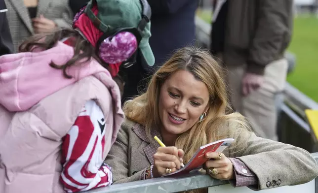 Wrexham co-owners Ryan Reynolds' wife Blake Lively, right, gives autographs to fans before the English League One soccer match between Wrexham and Charlton Athletic at the Racecourse ground in Wrexham, Wales, Saturday, April 26, 2025. (AP Photo/Jon Super)