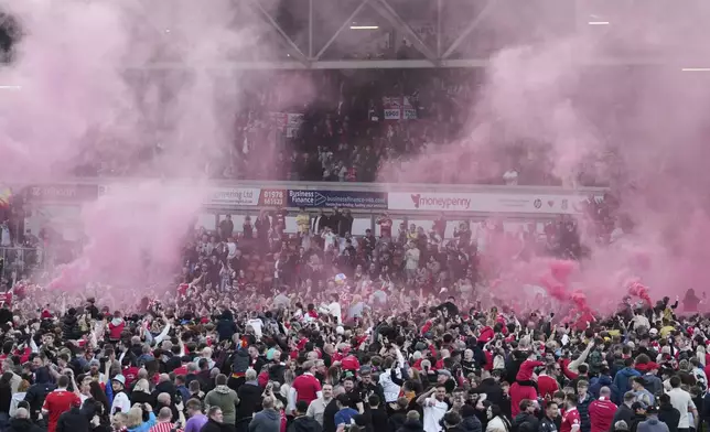 Wrexham players celebrate with fans as they win the English League One soccer match between Wrexham and Charlton Athletic at the Racecourse ground in Wrexham, Wales, Saturday, April 26, 2025. (AP Photo/Jon Super)