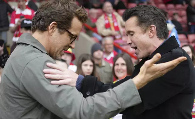 Wrexham co-owners Ryan Reynolds, left, and Rob McElhenney, right, speak before the English League One soccer match between Wrexham and Charlton Athletic at the Racecourse ground in Wrexham, Wales, Saturday, April 26, 2025. (AP Photo/Jon Super)