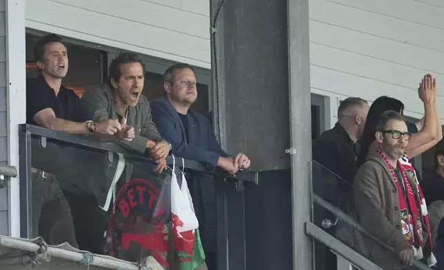 Wrexham co-owners Rob McElhenney, left, and Ryan Reynolds, second left, react during the English League One soccer match between Wrexham and Charlton Athletic at the Racecourse ground in Wrexham, Wales, Saturday, April 26, 2025. (AP Photo/Jon Super)