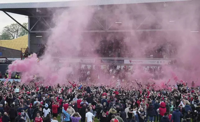 Wrexham players celebrate with fans as they win the English League One soccer match between Wrexham and Charlton Athletic at the Racecourse ground in Wrexham, Wales, Saturday, April 26, 2025. (AP Photo/Jon Super)