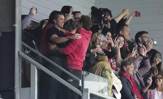 Wrexham co-owners Ryan Reynolds, center, and Rob McElhenney celebrate at the end of the English League One soccer match between Wrexham and Charlton Athletic at the Racecourse ground in Wrexham, Wales, Saturday, April 26, 2025. (AP Photo/Jon Super)
