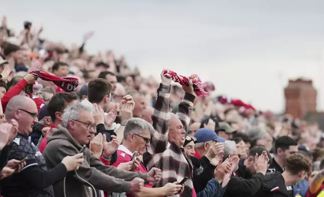 Wrexham fans watch the English League One soccer match between Wrexham and Charlton Athletic at the Racecourse ground in Wrexham, Wales, Saturday, April 26, 2025. (AP Photo/Jon Super)