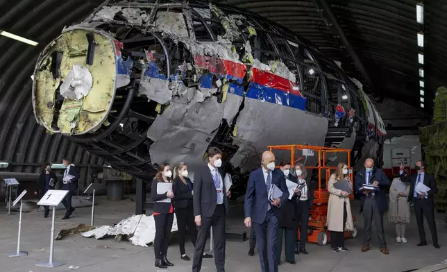 FILE - Judges and lawyers view the wreckage of a Malaysia Airlines passenger jet at the Gilze-Rijen Air Base, Netherlands, on May 26, 2021. (AP Photo/Peter Dejong, Pool, File)