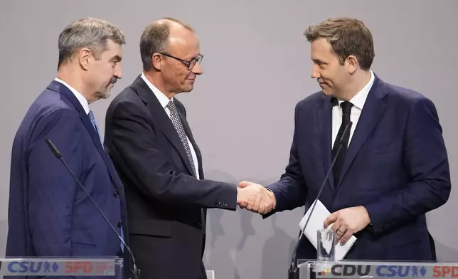 Friedrich Merz, Christian Democratic Union party chairman shakes hands with the Social Democratic Party co-leaders Lars Klingbeil, next to Markus Soeder, chairman of Bavarian's Christian Social Union party, after reaching an agreement between their parties on a coalition for a new German government at a news conference in Berlin, Germany, Wednesday, April 9, 2025. (AP Photo/Ebrahim Noroozi)