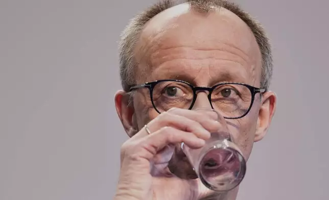 Friedrich Merz, Christian Democratic Union party chairman, drinks water during a press conference after reaching an agreement between their parties on a coalition for a new German government at a news conference in Berlin, Germany, Wednesday, April 9, 2025. (AP Photo/Ebrahim Noroozi)