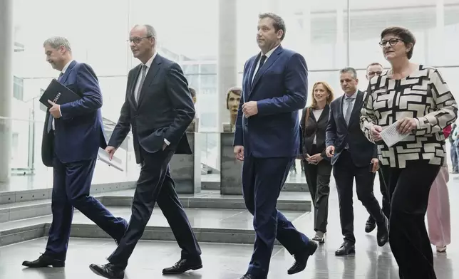 Markus Soeder, chairman of Bavarian's Christian Social Union party, Friedrich Merz, Christian Democratic Union party chairman and the Social Democratic Party co-leaders Lars Klingbeil and Saskia Esken, walk together after reaching an agreement between their parties on a coalition for a new German government at a news conference in Berlin, Germany, Wednesday, April 9, 2025. (AP Photo/Ebrahim Noroozi)
