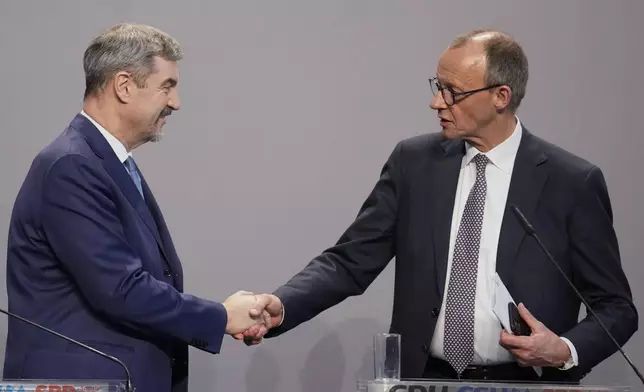 Markus Soeder, chairman of Bavarian's Christian Social Union party and Friedrich Merz, Christian Democratic Union party chairman, shake hands after reaching an agreement between their parties on a coalition for a new German government at a news conference in Berlin, Germany, Wednesday, April 9, 2025. (AP Photo/Ebrahim Noroozi)