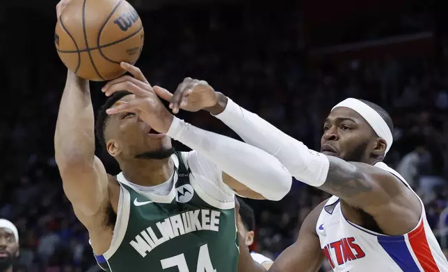 Milwaukee Bucks forward Giannis Antetokounmpo (34) is fouled by Detroit Pistons forward Paul Reed (7) while trying to take a shot during the first half of an NBA basketball game Friday, April 11, 2025, in Detroit. (AP Photo/Duane Burleson)
