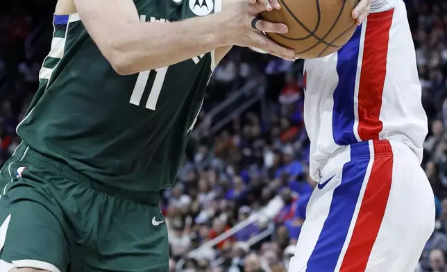 Milwaukee Bucks center Brook Lopez (11) is fouled by Detroit Pistons forward Ausar Thompson, right, while going to the basket during the first half of an NBA basketball game Friday, April 11, 2025, in Detroit. (AP Photo/Duane Burleson)