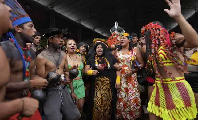 Brazilian Minister of Indigenous Peoples Sonia Guajajara, center, joins people at the annual Free Earth camp, where Brazil's Indigenous communities discuss rights, territorial protection and their role in COP30, which will take place for the first time in the Amazon, in Brasilia, Brazil, Tuesday, April 8, 2025. (AP Photo/Eraldo Peres)