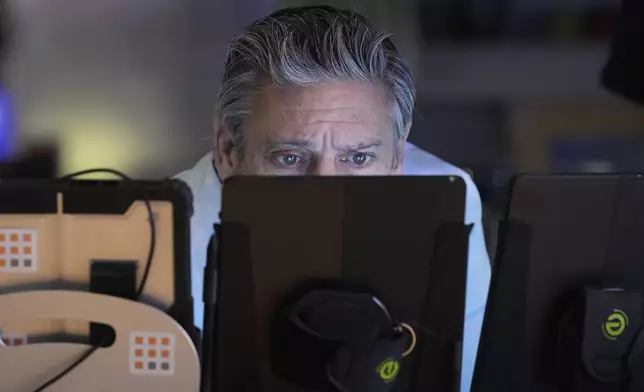 Trader John Romolo works on the floor of the New York Stock Exchange, Friday, April 25, 2025. (AP Photo/Richard Drew)
