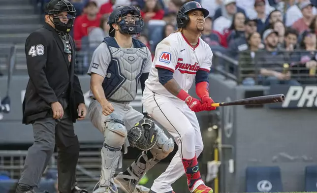 Cleveland Guardians' Jose Ramirez, right, watches his three-run home run off New York Yankees starting pitcher Clarke Schmidt with catcher Austin Wells, center, and umpire Nick Mahrley, left, during the third inning of a baseball game in Cleveland, Monday, April 21, 2025. (AP Photo/Phil Long)