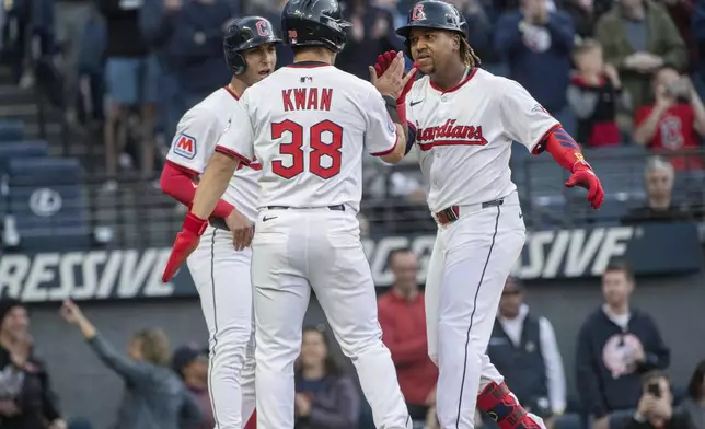Cleveland Guardians' Steven Kwan (38) and Brayan Rocchio, left rear, congratulate Jose Ramirez, right, after Ramirez's three-run home run off New York Yankees starting pitcher Clarke Schmidt during the third inning of a baseball game in Cleveland, Monday, April 21, 2025. (AP Photo/Phil Long)