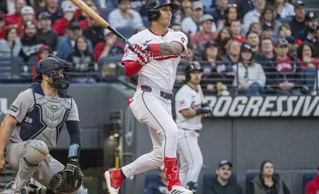 Cleveland Guardians' Brayan Rocchio watches his RBI single off New York Yankees starting pitcher Clarke Schmidt with catcher Austin Wells during the third inning of a baseball game in Cleveland, Monday, April 21, 2025. (AP Photo/Phil Long)