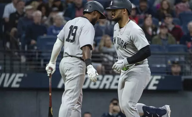 New York Yankees' Jasson Dominguez, right, is greeted by Pablo Reyes (19) after his two-run home run off Cleveland Guardians starting pitcher Gavin Williams during the seventh inning of a baseball game in Cleveland, Monday, April 21, 2025. (AP Photo/Phil Long)