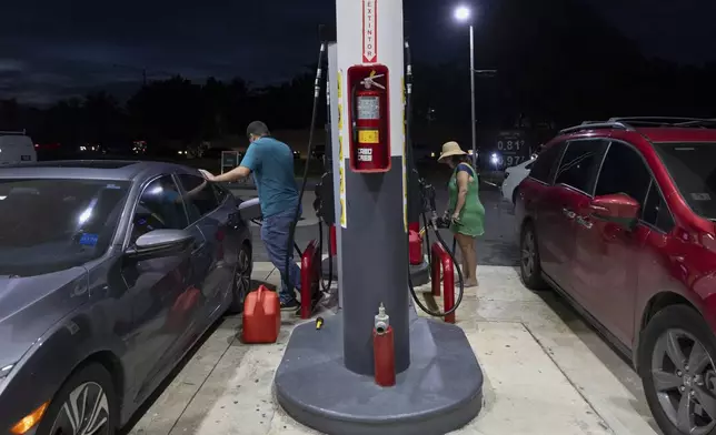 Drivers fill up fuel containers at a gas station during an island-wide blackout in San Juan, Puerto Rico, Wednesday, April 16, 2025. (AP Photo/Alejandro Granadillo)
