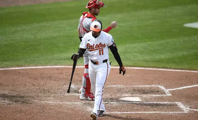 Baltimore Orioles' Jordan Westburg, front, walks back to the dugout past Cincinnati Reds catcher Austin Wynns, back, after he struck out during the fourth inning of a baseball game, Sunday, April 20, 2025, in Baltimore. (AP Photo/Nick Wass)