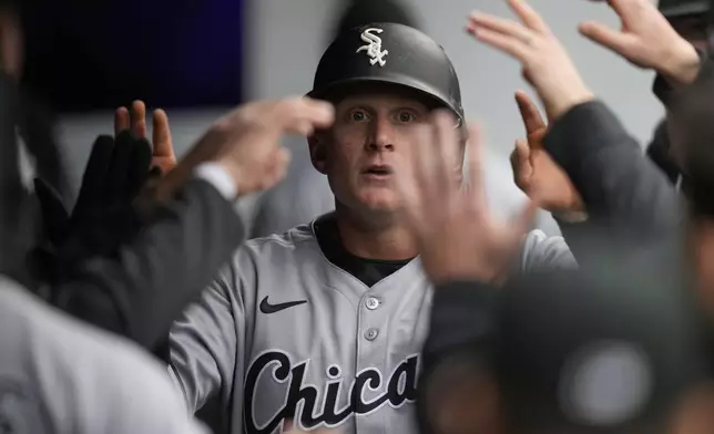 Chicago White Sox's Andrew Vaughn is congratulated in the dugout after scoring in the first inning of a baseball game against the Cleveland Guardians in Cleveland, Wednesday, April 9, 2025. (AP Photo/Sue Ogrocki)