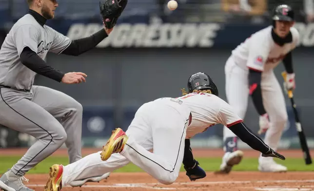 Chicago White Sox starting pitcher Sean Burke reaches for the ball as Cleveland Guardians' Jose Ramirez, center, slides into home plate to score in the first inning of a baseball game in Cleveland, Wednesday, April 9, 2025. (AP Photo/Sue Ogrocki)