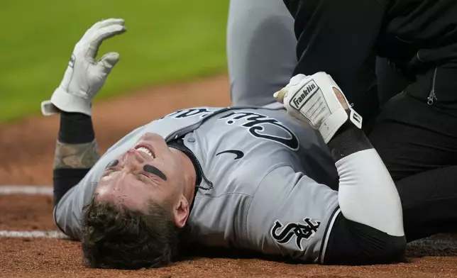 Chicago White Sox's Korey Lee grimaces after injuring himself at first base in the sixth inning of a baseball game against the Cleveland Guardians in Cleveland, Wednesday, April 9, 2025. (AP Photo/Sue Ogrocki)