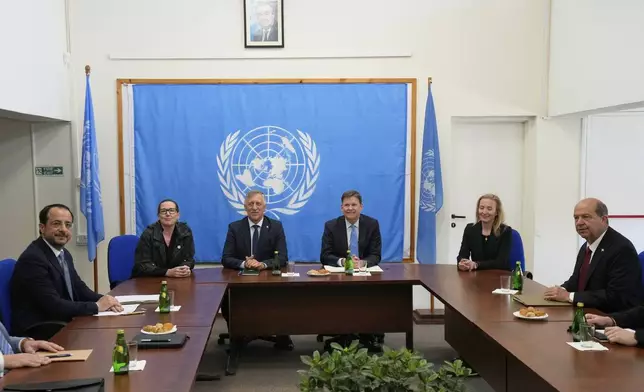 Cyprus' President Nikos Christodoulides, left, and Turkish Cypriot leader Ersin Tatar, right, meet with the U.N. Secretary General's Special Representative in Cyprus Colin Stewart, center right, at a U.N compound inside the U.N controlled buffer zone at abandoned Nicosia airport in divided capital Nicosia, Cyprus, Wednesday, April 2, 2025. (AP Photo/Petros Karadjias)
