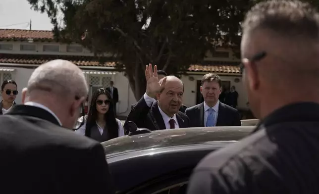 Turkish Cypriot leader Ersin Tatar waves to the media as he gets into a car after a meeting with the Cyprus' President Nikos Christodoulides and U.N. Secretary General's Special Representative in Cyprus Colin Stewart, back right, at a U.N compound inside the U.N controlled buffer zone at abandoned Nicosia airport in divided capital Nicosia, Cyprus, Wednesday, April 2, 2025. (AP Photo/Petros Karadjias)