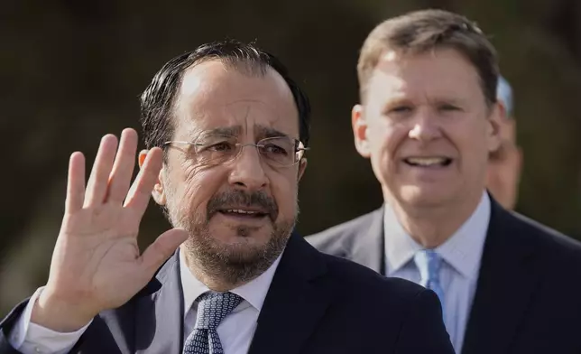 Cyprus' President Nikos Christodoulides, left, waves as he arrives at a U.N compound for a meeting with Turkish Cypriot leader Ersin Tatar, inside the U.N controlled buffer zone at abandoned Nicosia airport in divided capital Nicosia, Cyprus, Wednesday, April 2, 2025. (AP Photo/Petros Karadjias)