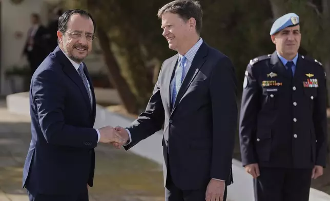 Cyprus' President Nikos Christodoulides, left, shakes hands with the U.N. Secretary General's Special Representative in Cyprus Colin Stewart before a meeting with Turkish Cypriot leader Ersin Tatar at a U.N compound inside the U.N controlled buffer zone at abandoned Nicosia airport in divided capital Nicosia, Cyprus, Wednesday, April 2, 2025. (AP Photo/Petros Karadjias)