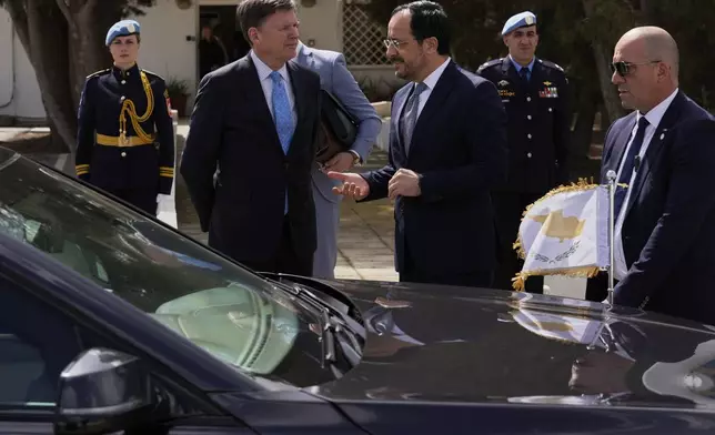 Cyprus' President Nikos Christodoulides, center right, and the U.N. Secretary General's Special Representative in Cyprus Colin Stewart, center left, talk after a meeting with the Turkish Cypriot leader Ersin Tatar, at a U.N compound inside the U.N controlled buffer zone at abandoned Nicosia airport in divided capital Nicosia, Cyprus, Wednesday, April 2, 2025. (AP Photo/Petros Karadjias)