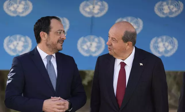Cyprus' President Nikos Christodoulides, left, and Turkish Cypriot leader Ersin Tatar talk before their meeting with the U.N. Secretary General's Special Representative in Cyprus Colin Stewart, at a U.N compound inside the U.N controlled buffer zone at abandoned Nicosia airport in divided capital Nicosia, Cyprus, Wednesday, April 2, 2025. (AP Photo/Petros Karadjias)