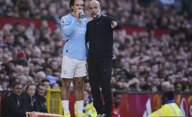 Manchester City's head coach Pep Guardiola talks to Jack Grealish during the English Premier League soccer match between Manchester City and Manchester United in Manchester, England, Sunday, April 6, 2025. (AP Photo/Dave Thompson)
