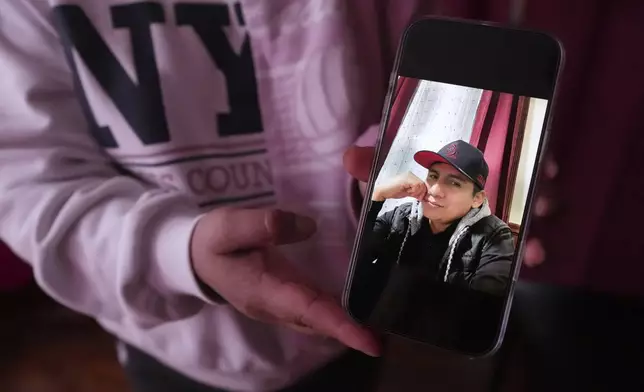 Marilu Domingo Ortiz, whose husband was taken into custody by ICE agents after they smashed a window of their family car, shows a photograph of her spouse, Juan Francisco Mendez, at their home, Wednesday, April 16, 2025, in New Bedford, Mass. (AP Photo/Charles Krupa)