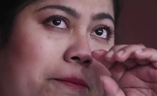 While wiping away a tear, Marilu Domingo Ortiz, whose husband was taken into custody by ICE agents after they smashed a window of their family car, describes the arrest during an interview at their home, Wednesday, April 16, 2025, in New Bedford, Mass. (AP Photo/Charles Krupa)