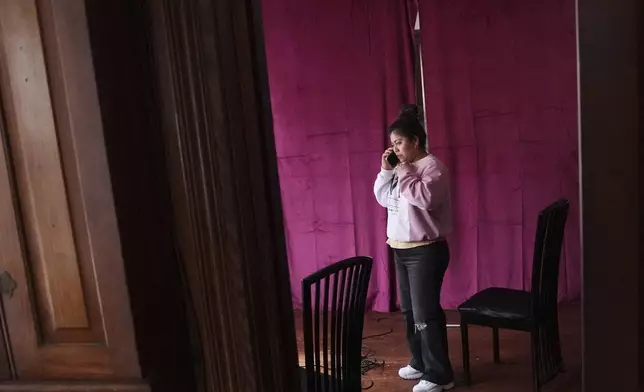 Marilu Domingo Ortiz, whose husband was taken into custody by ICE agents after they smashed a window of their family car, talks on her phone at their home, Wednesday, April 16, 2025, in New Bedford, Mass. (AP Photo/Charles Krupa)