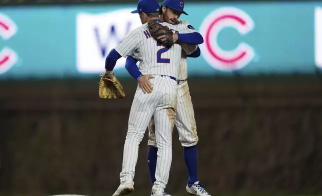 Chicago Cubs second baseman Nico Hoerner (2), left, and Dansby Swanson celebrate their team's win over the Los Angeles Dodgers in a baseball game Wednesday, April 23, 2025, in Chicago. (AP Photo/Erin Hooley)
