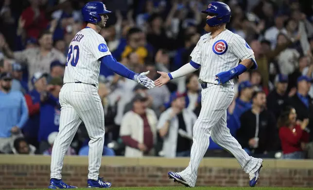Chicago Cubs Kyle Tucker (30), left, and Justin Turner celebrate after both scoring on a single from Dansby Swanson during the fifth inning of a baseball game against the Los Angeles Dodgers, Wednesday, April 23, 2025, in Chicago. (AP Photo/Erin Hooley)