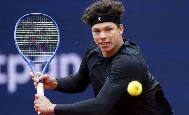 Ben Shelton from the US returns the ball to Italy's Luciano Darderi during the men's singles quarterfinal match at the Munich tennis tournament, in Munich, Germany, Friday April 18, 2025. (Sven Hoppe/dpa via AP)