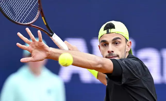 Argentina's Francisco Cerundolo returns the ball to Belgium's David Goffin during the men's singles quarterfinal match at the Munich tennis tournament, in Munich, Germany, Friday April 18, 2025. (Sven Hoppe/dpa via AP)