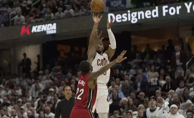 Cleveland Cavaliers guard Donovan Mitchell (45) shoots over Miami Heat forward Andrew Wiggins (22) in the second half in Game 1 of an NBA first-round playoff series, Sunday, April 20, 2025, in Cleveland. (AP Photo/Sue Ogrocki)